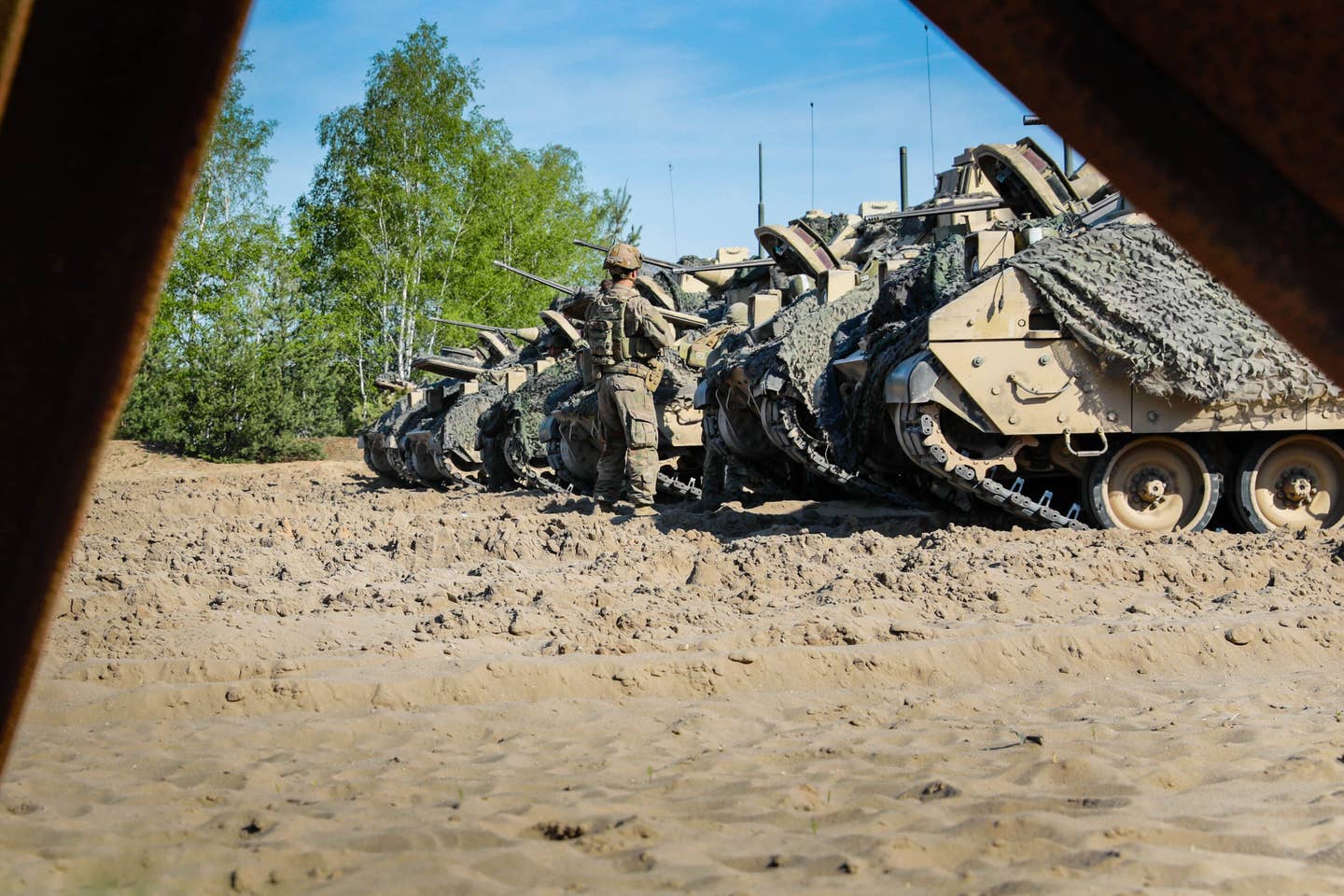 U.S. soldiers arrive on their assigned M2A3 Bradley fighting vehicles prior to live demolition training as part of Defender 22 at Oberlausitz Training Area, Germany, May 10, 2022. <em>Credit: U.S. Army National Guard photo by Staff Sgt. Gabriel Rivera</em>