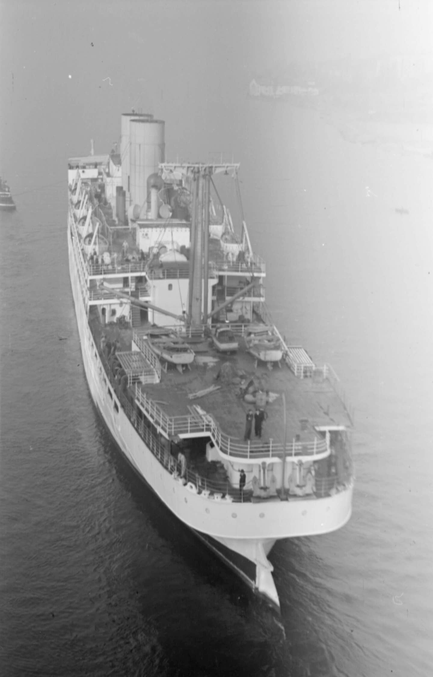 A rear view of HMS <em>Menestheus</em> being towed out of False Creek toward English Bay. <em>James Crookall via Wikimedia Commons</em>