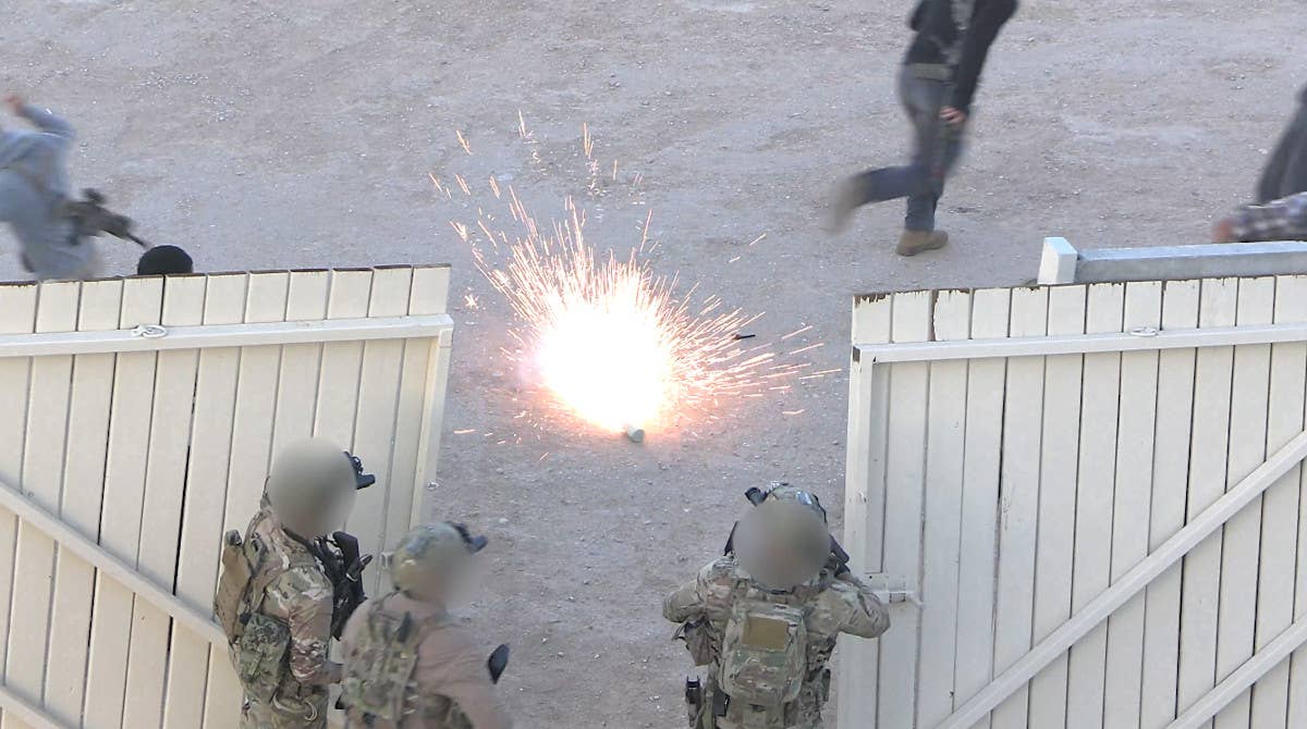 SEALs disperse some of the faux militants with a flashbang-type grenade, or a device meant to simulate one. <em>USMC capture</em>