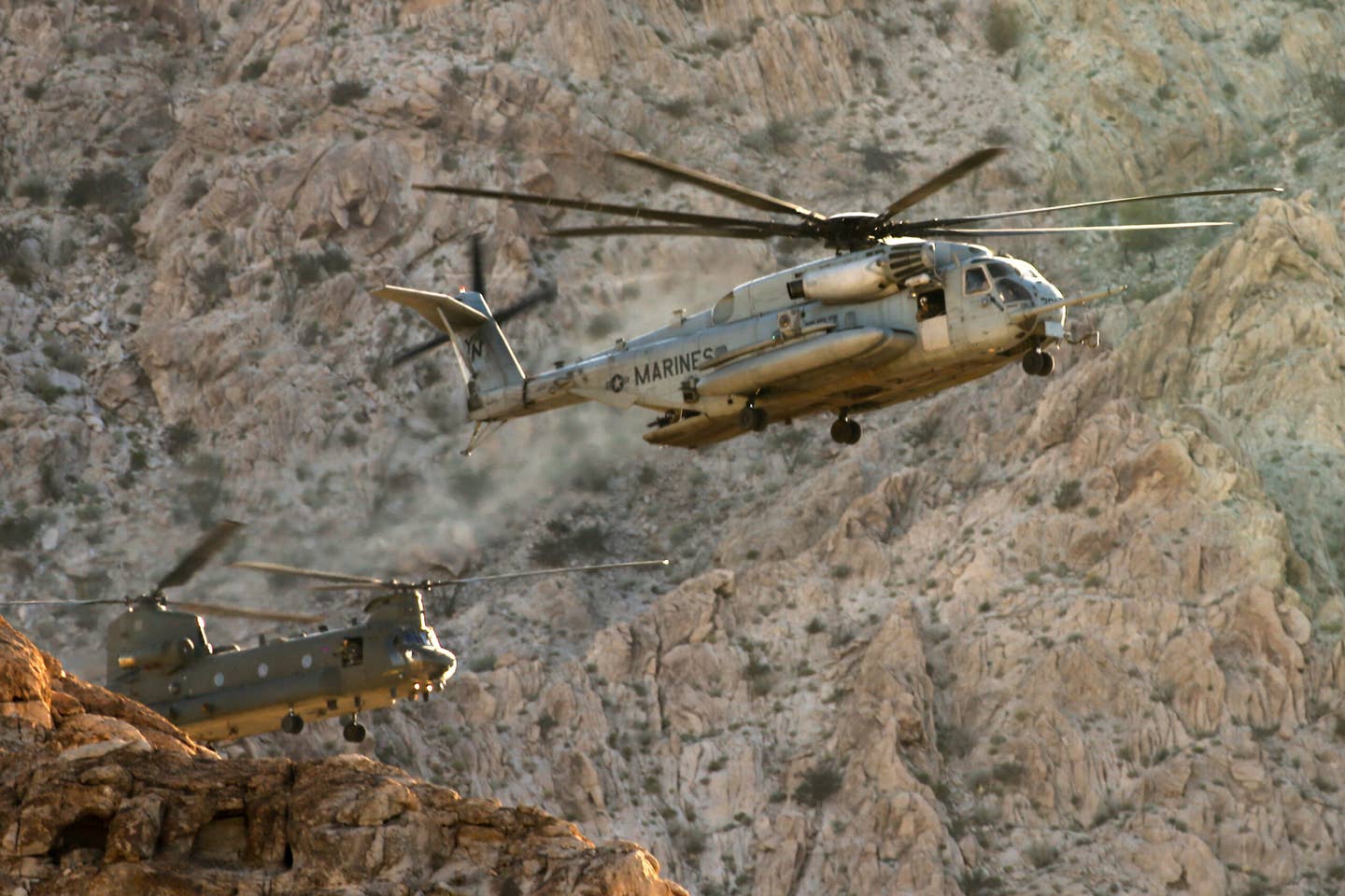 A US Marine Corps CH-53E Super Stallion, in front, flies together with a Royal Air Force Chinook, behind, during the consulate evacuation training. <em>USMC</em>