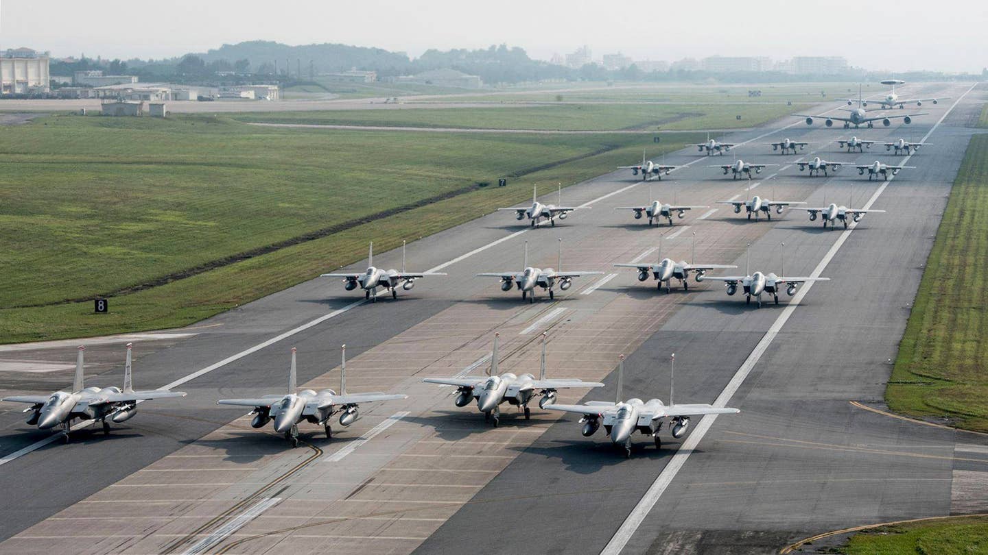 Air Force F-15C/D Eagles, along with a KC-135 tanker and an E-3 Sentry Airborne Warning and Control System (AWACS) radar plane, conduct an 'Elephant Walk' readiness exercise at Kadena in 2017. <em>USAF</em>