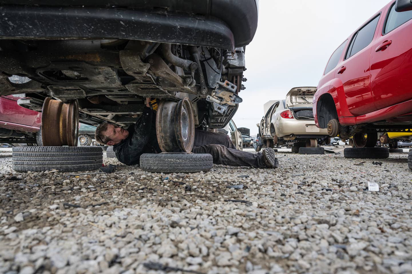 A mechanic extracts used parts at a salvage yard in Kentucky. <em>Jon Cherry, Getty Images</em>
