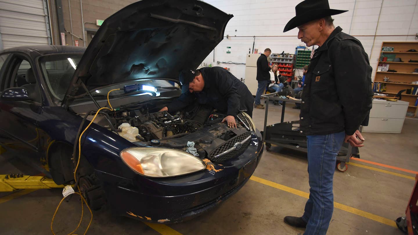 DENVER, CO - NOVEMBER 6: Senior fleet mechanic Res bacon stands back as he watches Mike Stueve, who graduated from the rehab program and is now an employee, work on a car in the auto-repair shop on November 6, 2017. The Denver Rescue Mission's New Life Rehab Program helps men and women who are homeless and struggling with sobriety to stay sober, hone their job readiness skills and get back to being a "self-sufficient, contributing citizen". One of the last phases of the program is getting the clients into work therapy. One work therapy option is working for the mission's auto-repair shop. (Photo by John Leyba/The Denver Post via Getty Images)