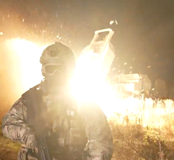 "Capt. HIMARS" in front of an M142 High Mobility Artillery Rocket System launching munitions. (Ukraine MoD screencap)