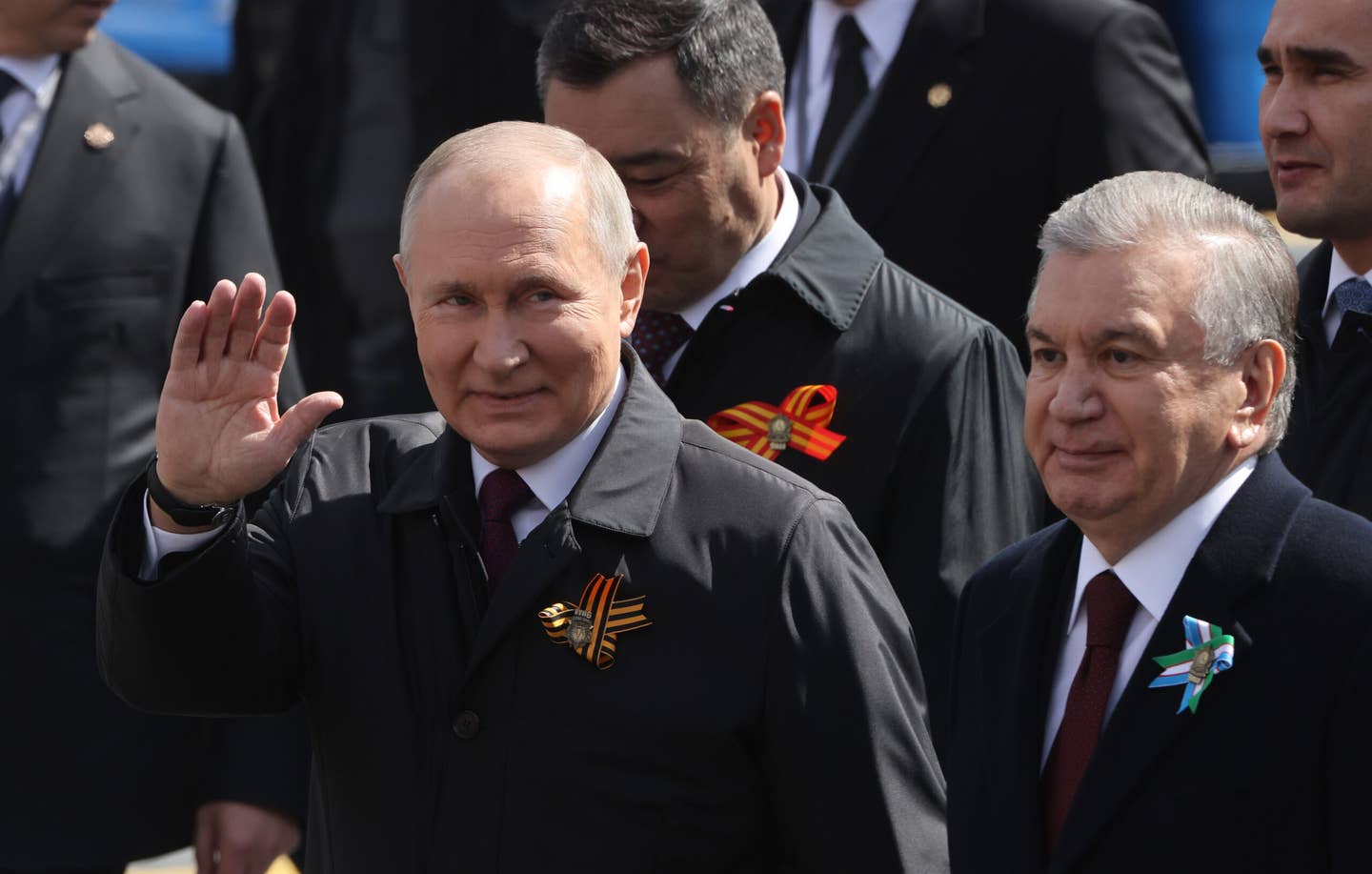 Russian President Vladimir Putin (left) waves as Uzbek President Shavkat Mirziyoyev (second from right) looks on while visiting Red Square for the Victory Day parade on May 9, 2023. <em>Photo by Contributor/Getty Images</em>