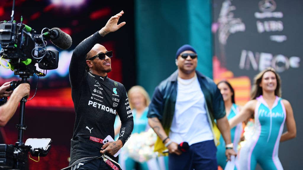 Lewis Hamilton of Great Britain and Mercedes walks out onto the grid prior to the F1 Grand Prix of Miami. LL Cool J and cheerleaders in background