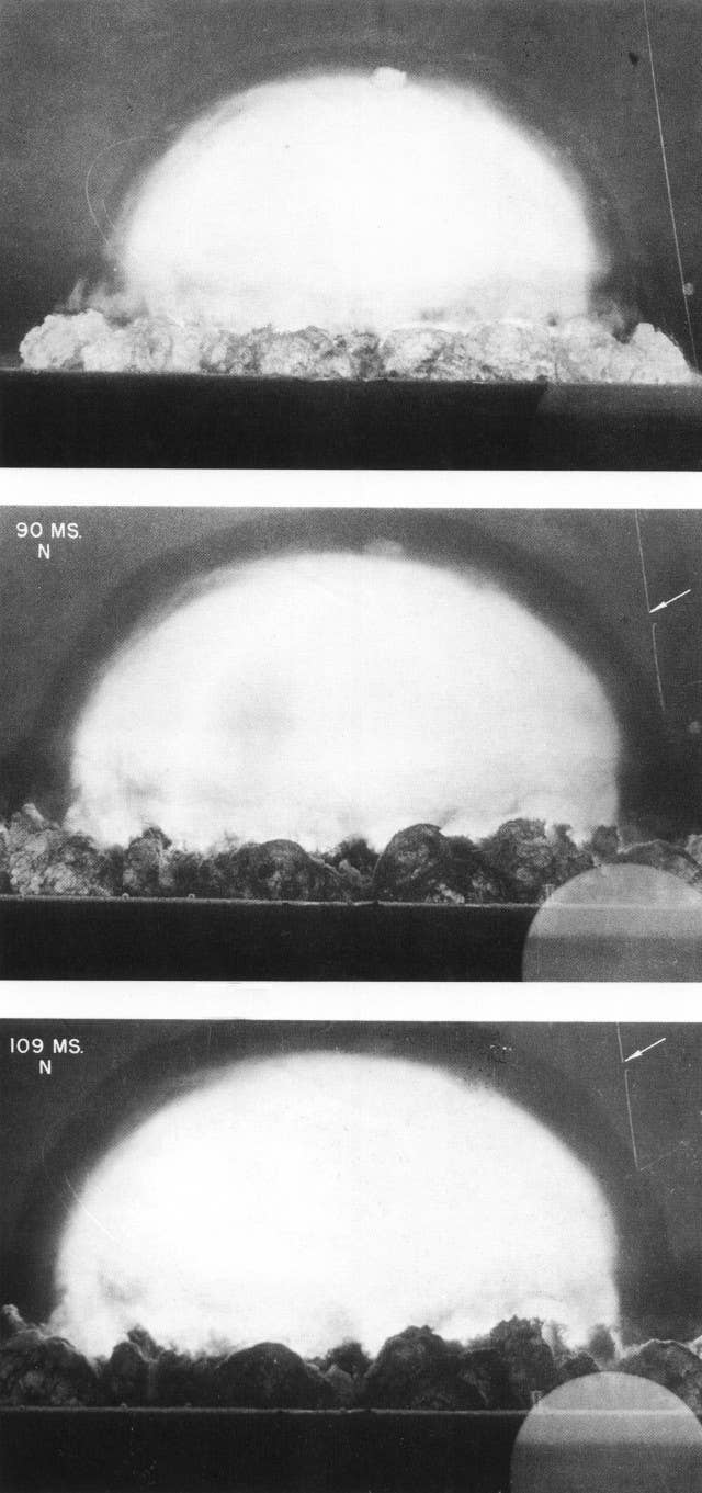 Trinity explosion between 90 and 109 milliseconds, showing optical refraction at the shock front. The barrage balloon cable can be seen to the right, with the 'break' highlighted by the arrow.<em> Berlyn Brixner/U.S. government via Wikimedia Commons</em>