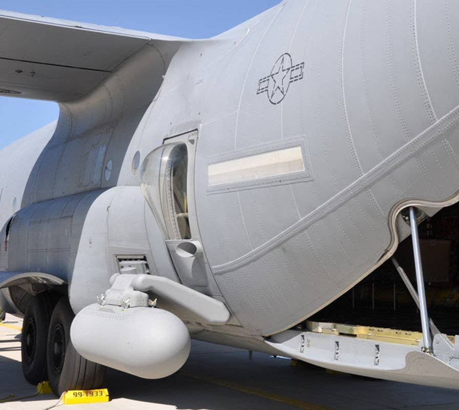 An example of a modified C-130 rear paratrooper door with an add-on pylon with a pod attached. <em>via&nbsp;ThinkDefence.co.uk</em>