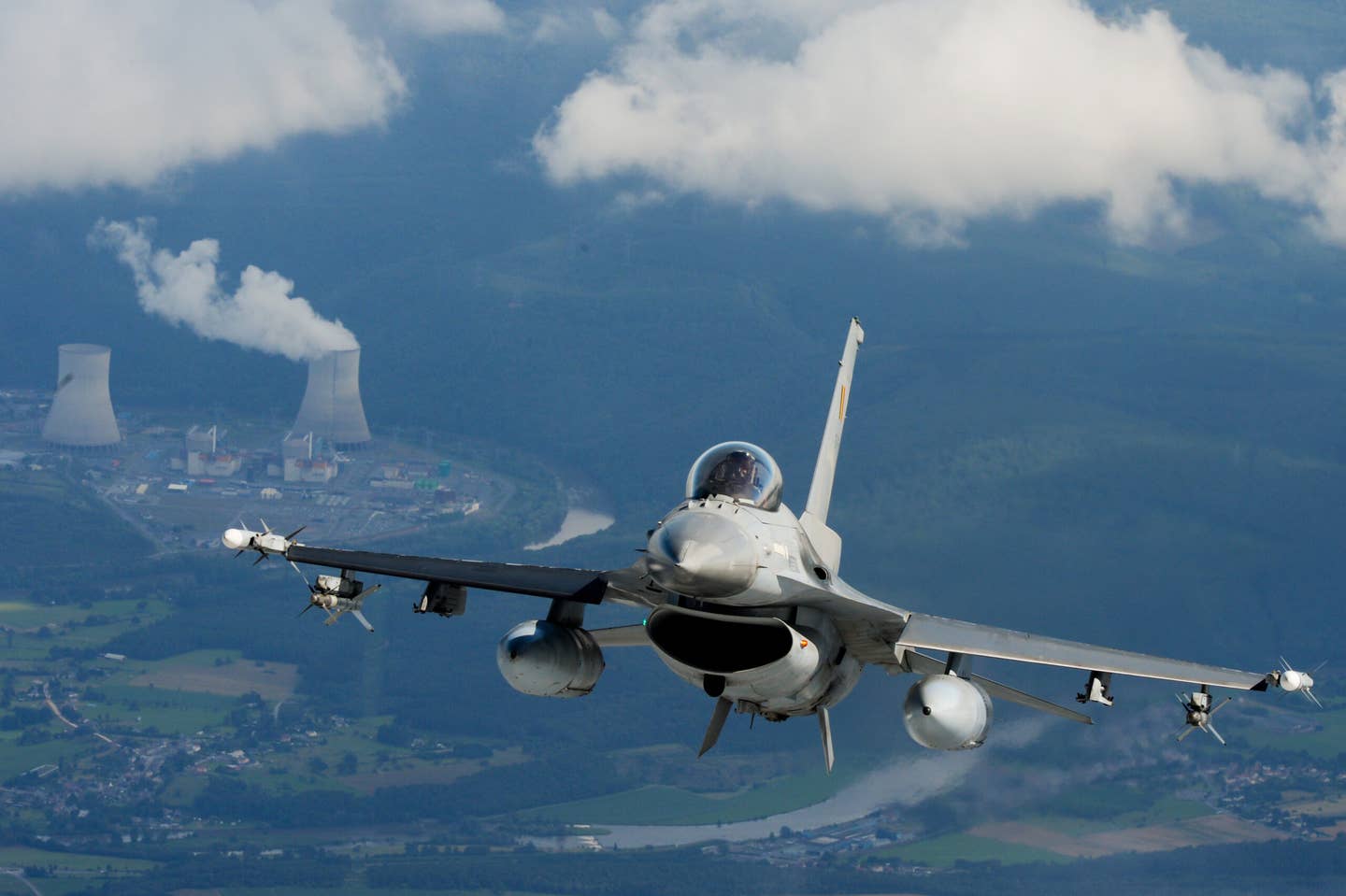 The Chooz Nuclear Power Plant in Chooz, France, can be seen in the background as a Belgian F-16 flies as part of the preparations for the Belgian National Day in 2012. <em>BRUNO FAHY/AFP/GettyImages</em>