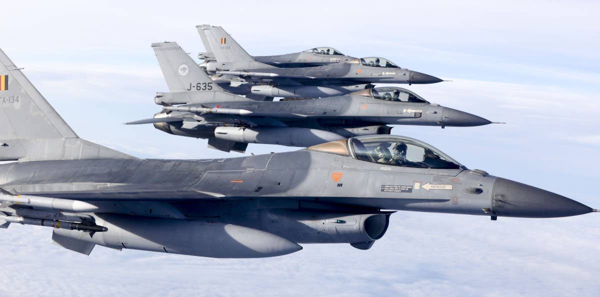 Belgian and Dutch F-16s fly in formation over the Netherlands prior to the signing of an agreement between Benelux countries to work together to monitor national airspace, in December 2016. <em>JERRY LAMPEN/AFP via Getty Images</em>
