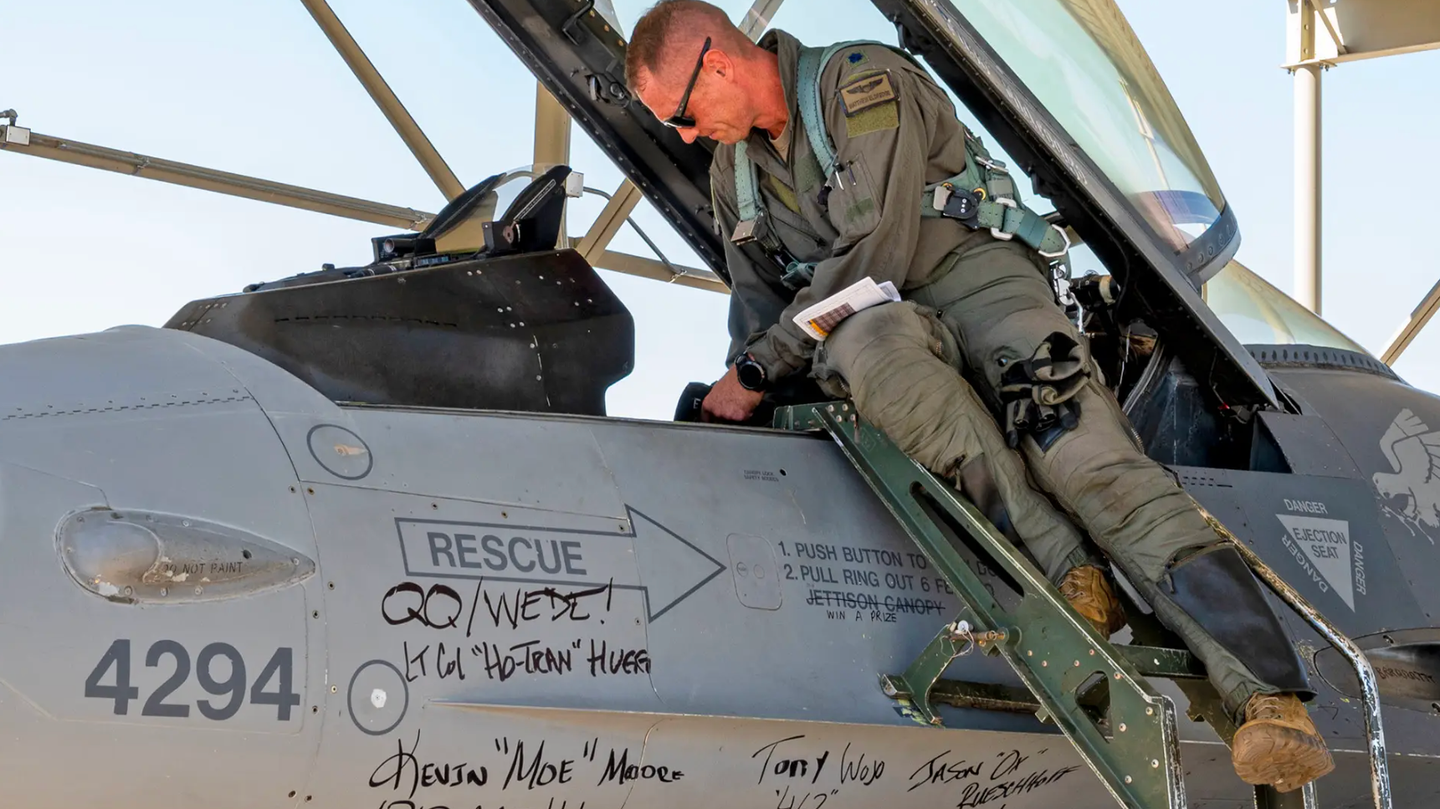 A member of the 309th Fighter Squadron prepares to fly a retiring Block 25 F-16 at Luke Air Force Base, Arizona, on September 6, 2022. Signatures from commanders, honorary commanders, and other members of the squadron cover the aircraft for its final send-off.&nbsp;<em>U.S. Air Force photo by Senior Airman David Busby</em>
