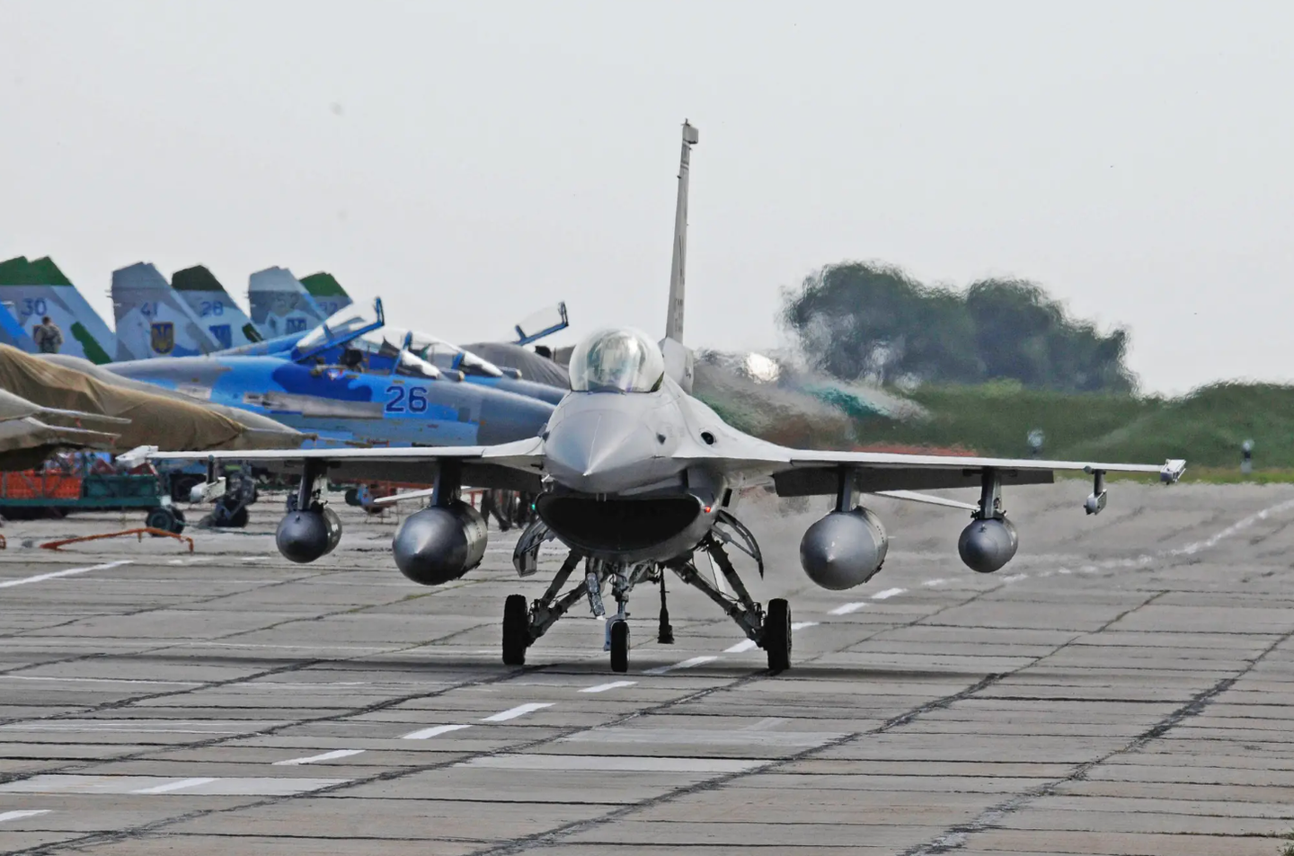 An Alabama Air National Guard F-16C taxies past Ukrainian Su-27 and MiG-29 fighter jets, on the ramp at Mirgorod Air Base, Ukraine, during an exercise in 2011.&nbsp;<em>U.S. Air Force</em><br>