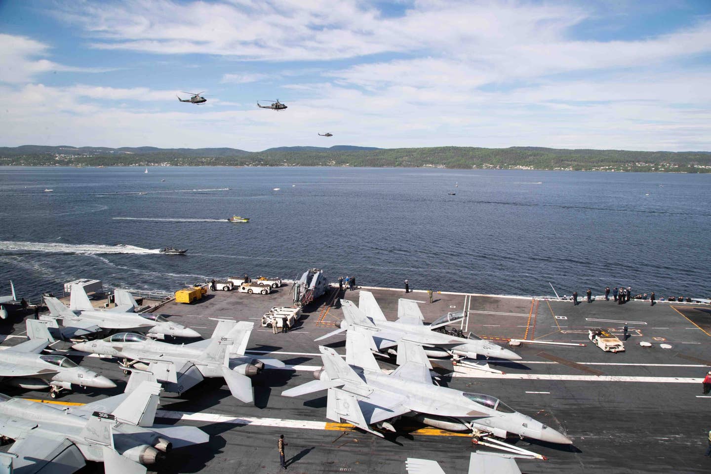 Three Norwegian military helicopters perform a fly-by of the flagship USS <em>Gerald R. Ford </em>(CVN 78) as the ship transits the Oslo fjord for its first port call in Oslo, Norway, May 24, 2023. <em>U.S. Navy Photo by Mass Communication Specialist 2nd Class Brian Glunt</em>