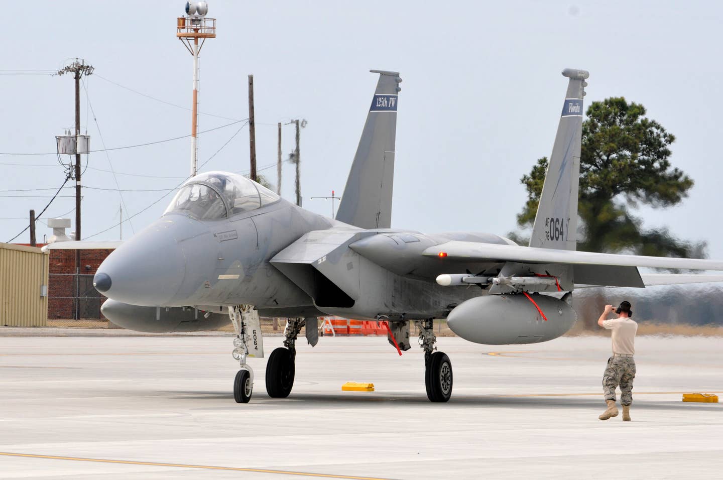 A crew chief from the 125th Fighter Wing, Florida ANG, marshals an F-15C into place following a sortie. This unit will replace its Eagles with F-35As. <em>U.S. Air Force Photo by Tech. Sgt. Shelley Gill</em>