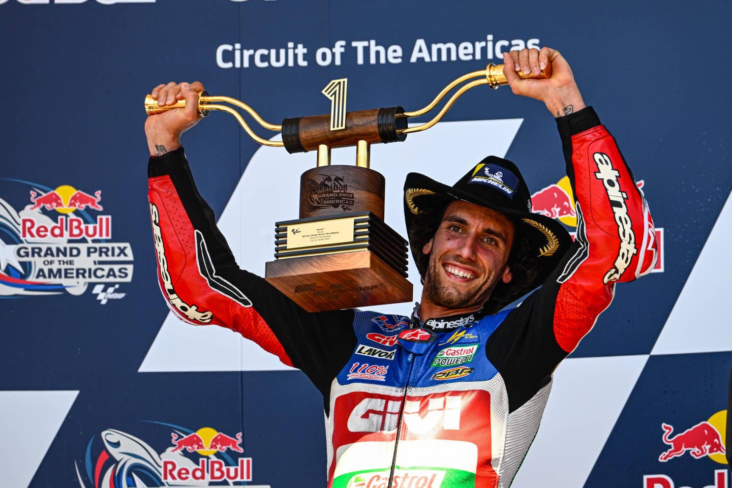 Alex Rins hoists the 2023 COTA trophy. <em>MotoGP</em>