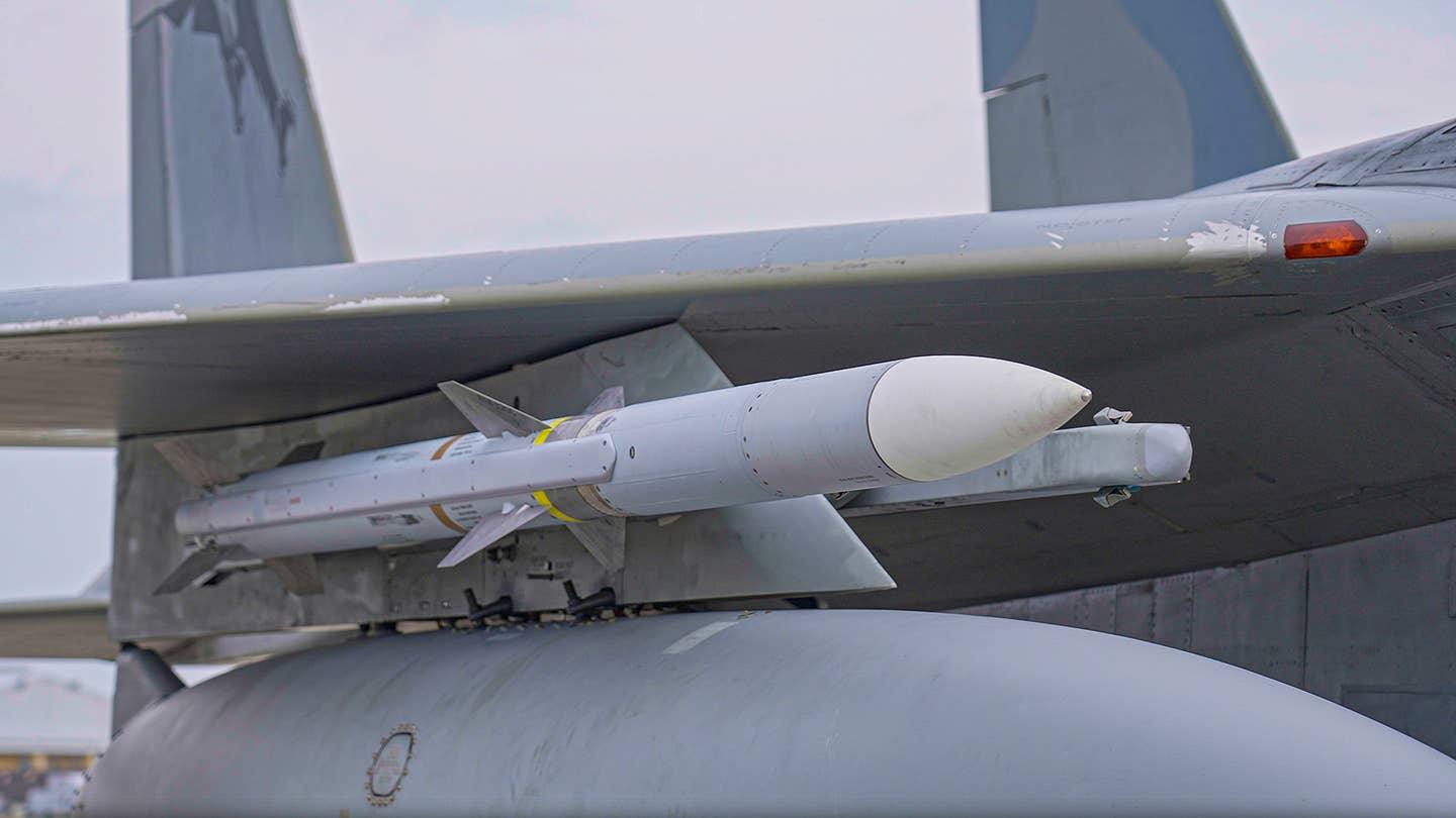 A Raytheon AIM-120 Advanced Medium-Range Air-to-Air Missile (AMRAAM) loaded on an F-15C during Combat Archer in May 2023 complete with a brown band to denote a live rocket motor, and a yellow band to denote that it has a live warhead. <em>Jamie Hunter</em>