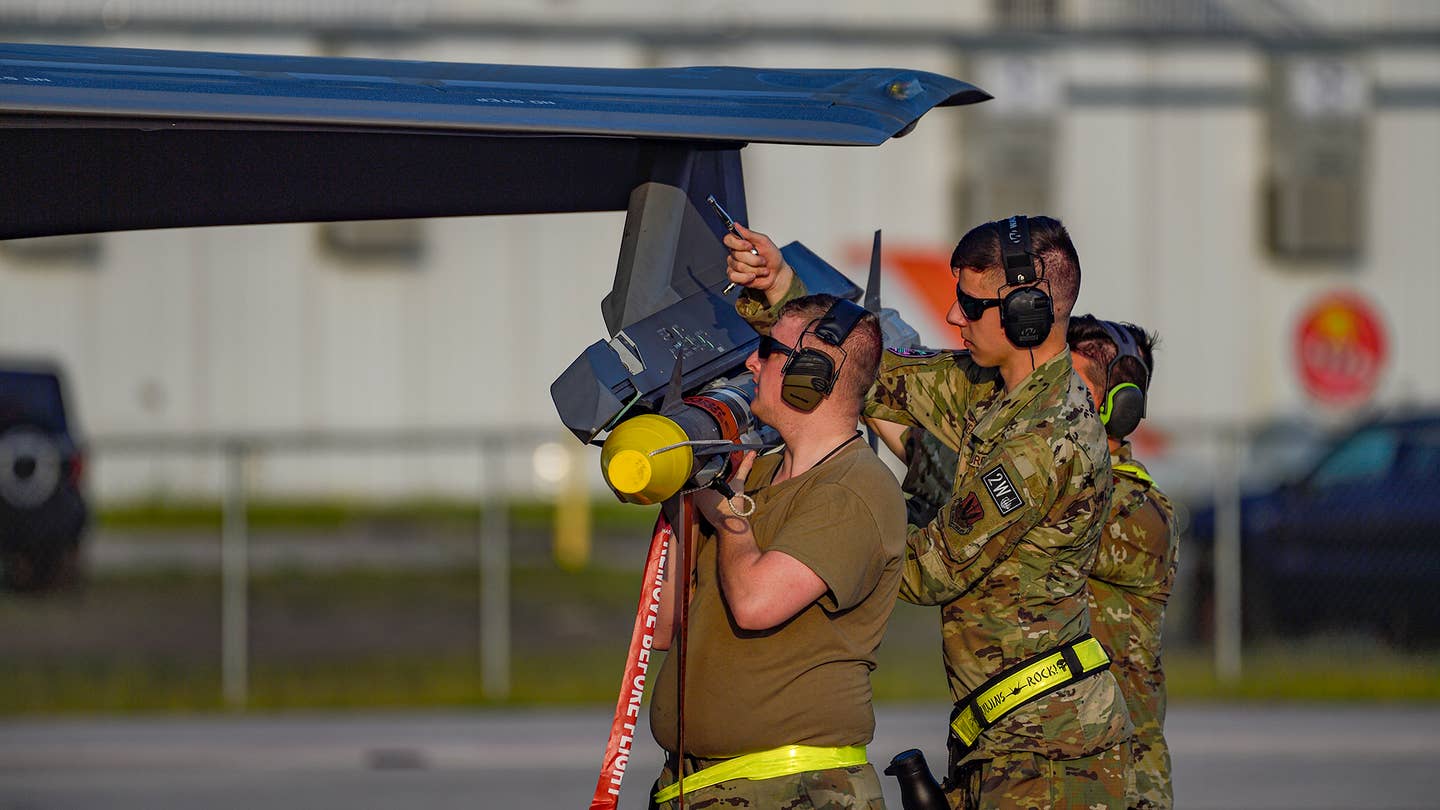 Attaching an AIM-9X to an F-35A wing pylon. AIM-120 AMRAAMs are only carried internally in the F-35. <em>Jamie Hunter</em>