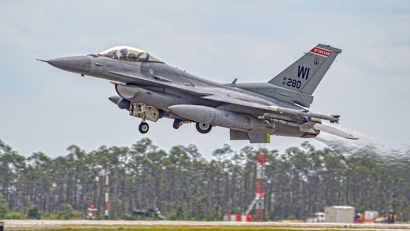 This F-16C carries an AIM-9M for a live firing. Note the brown missile band, denoting a live rocket motor. <em>Jamie Hunter</em>