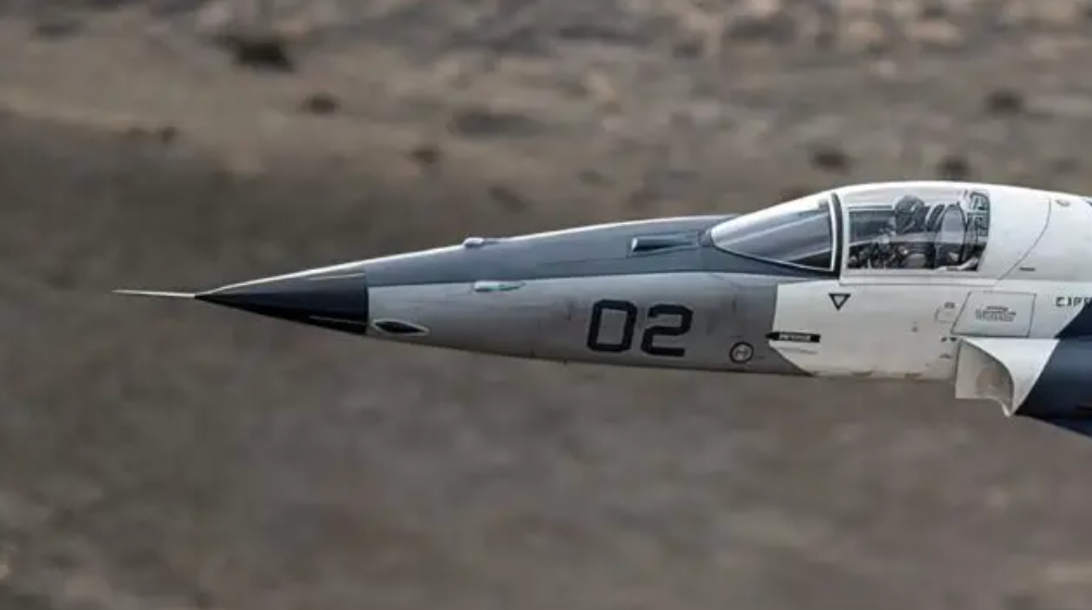 A zoomed-in shot of an F-5AT flight testing the TacIRST. The forward-staring device can be seen directly in front of the cockpit windscreen.&nbsp;<em>TacAir</em>
