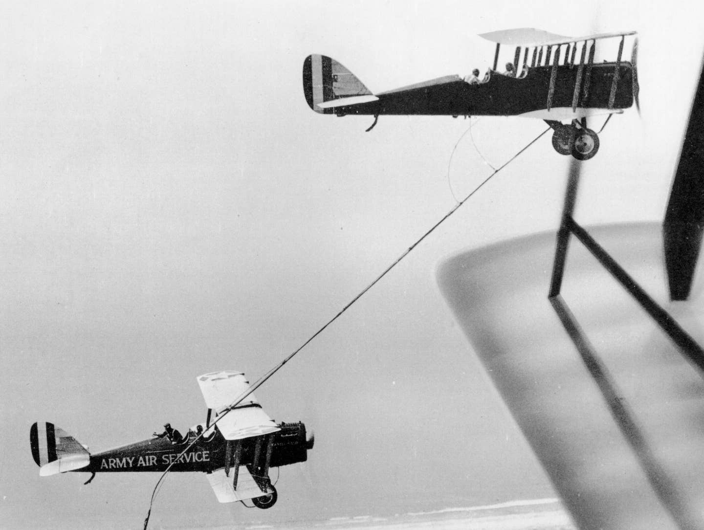 Another view of the DH-4B tanker as it trails its hose for the DH-4B receiver to grab over Rockwell Field. <em>U.S. Air Force</em><br><a href="https://www.afhistory.af.mil/FAQs/Fact-Sheets/Article/458986/1923-the-beginnings-of-inflight-refueling/undefined"></a>