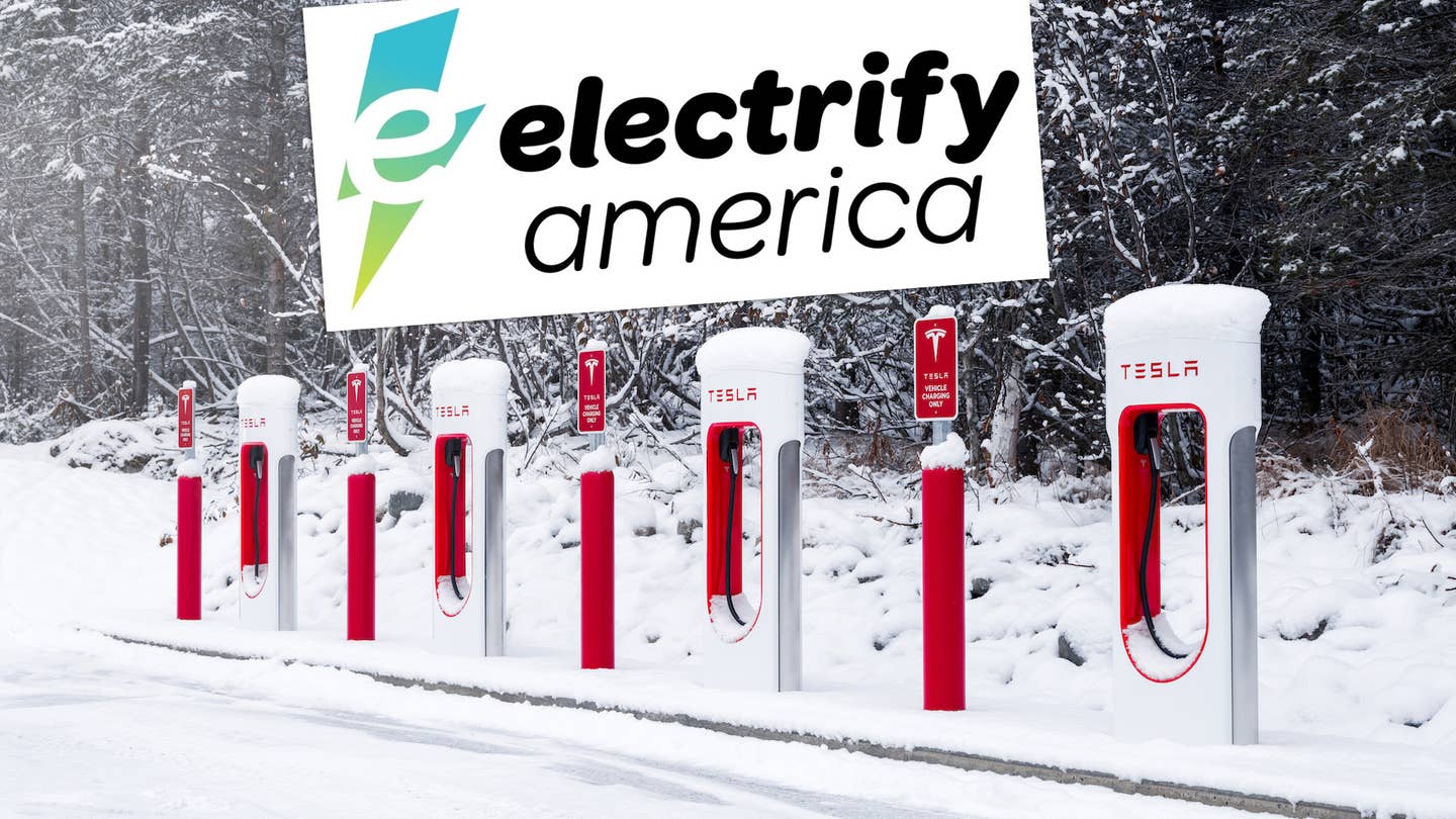 Electrify America logo hovers over a Tesla Supercharger station