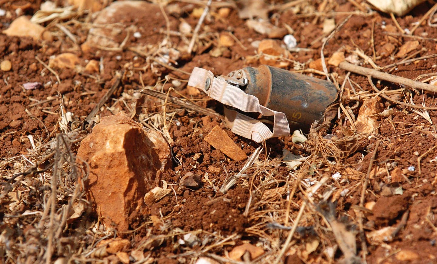 An unexploded cluster bomb identified by members of the Mine Advisory Group (MAG) rests in a backyard garden August 21, 2006 in Yohmor, Lebanon. (Photo by Scott Peterson/Getty Images)