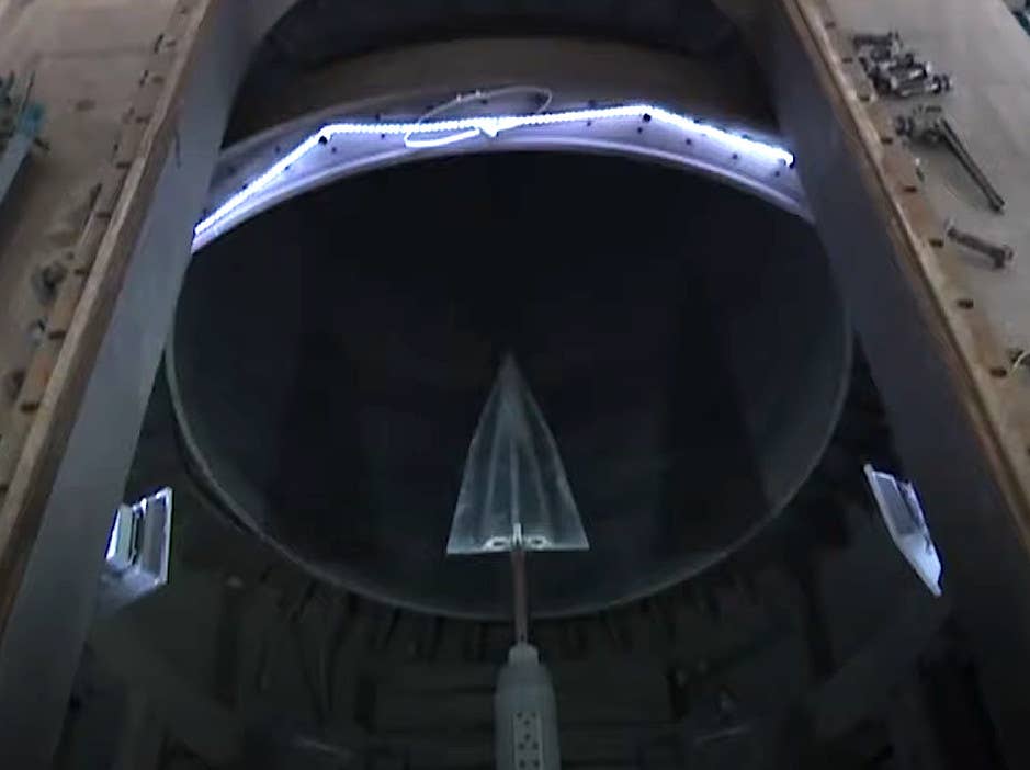 A screen capture showing a wedge-shaped test article in a wind tunnel in previous state media footage show in relation to the JF-22 project. <em>CGTN capture</em>