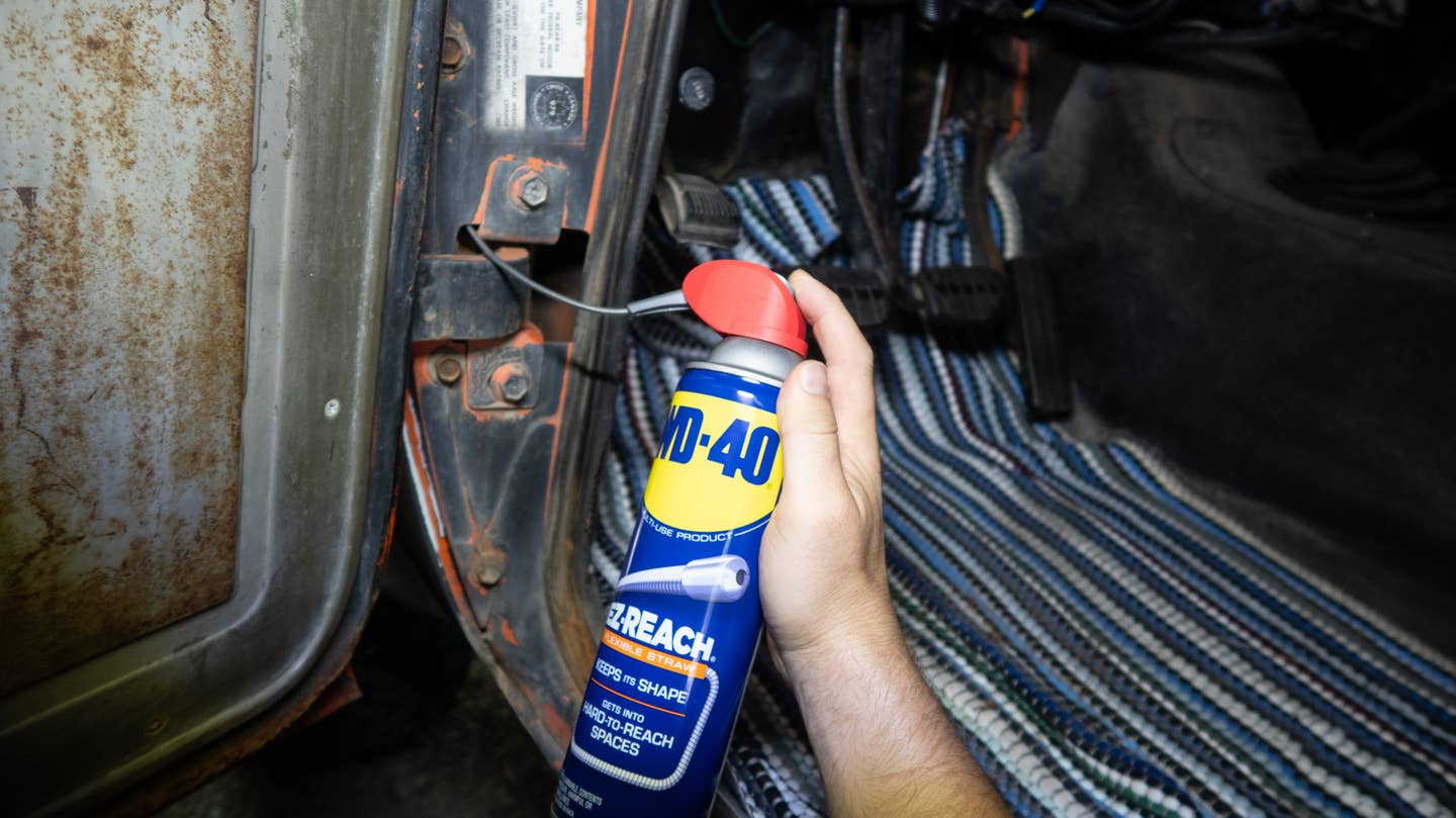 WD-40 EZ-REACH straw moving around a door hinge for easy lubrication.