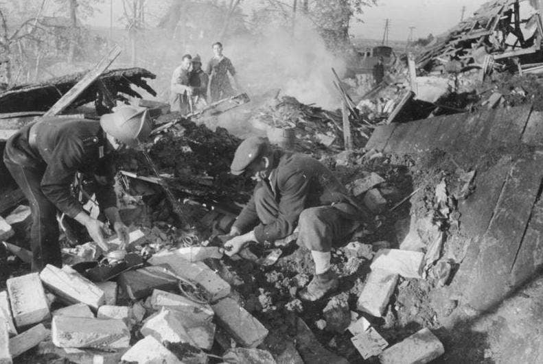 Rescue workers sift through the rubble in search of victims of a bombing raid in Hamburg sometime during World War II. <em>Bundesarchiv</em>
