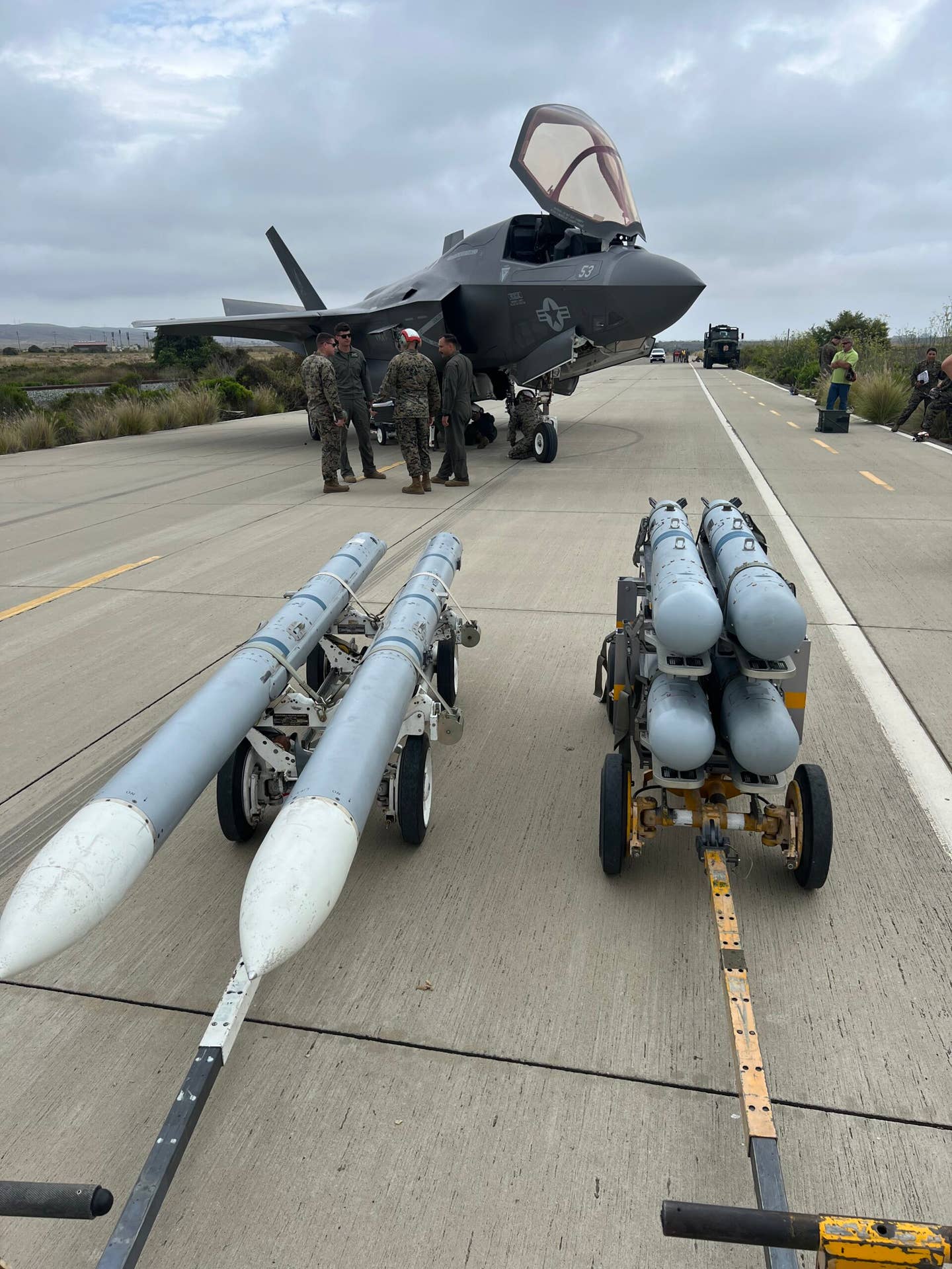 An F-35B about to be rearmed with inert AIM-120s and Stormbreakers on a stretch of road next to the Pacific coastline in California.