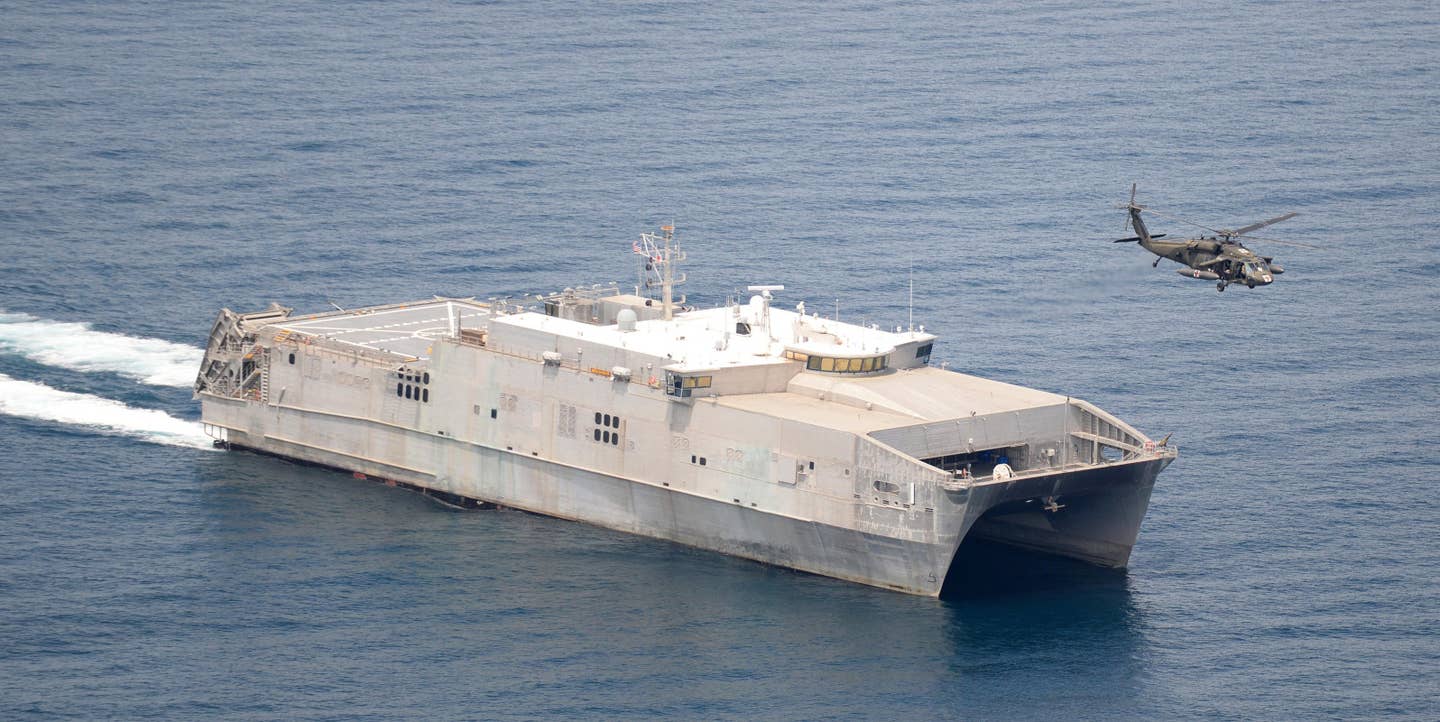USNS <em>Spearhead</em>, which was placed on ROS in 2020, seen off the coast of Panama in 2016. A US Army Black Hawk helicopter is also seen at right. <em>USN</em>