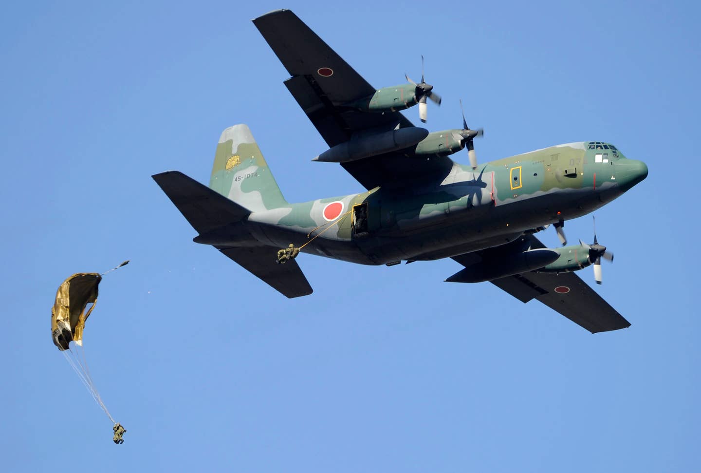 Japanese Ground Self-Defense Force airbone troops paradrop from a JASDF C-130. <em>TOSHIFUMI KITAMURA/AFP via Getty Images</em>