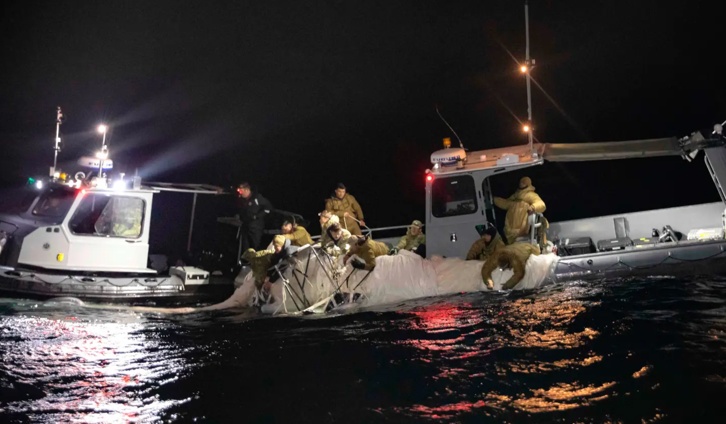 U.S. Navy personnel in small rigid hull inflatable boats manually pull portions of the Chinese surveillance balloon’s envelope and its payload out of the water, February 6, 2023. <em>U.S. Navy </em><br>