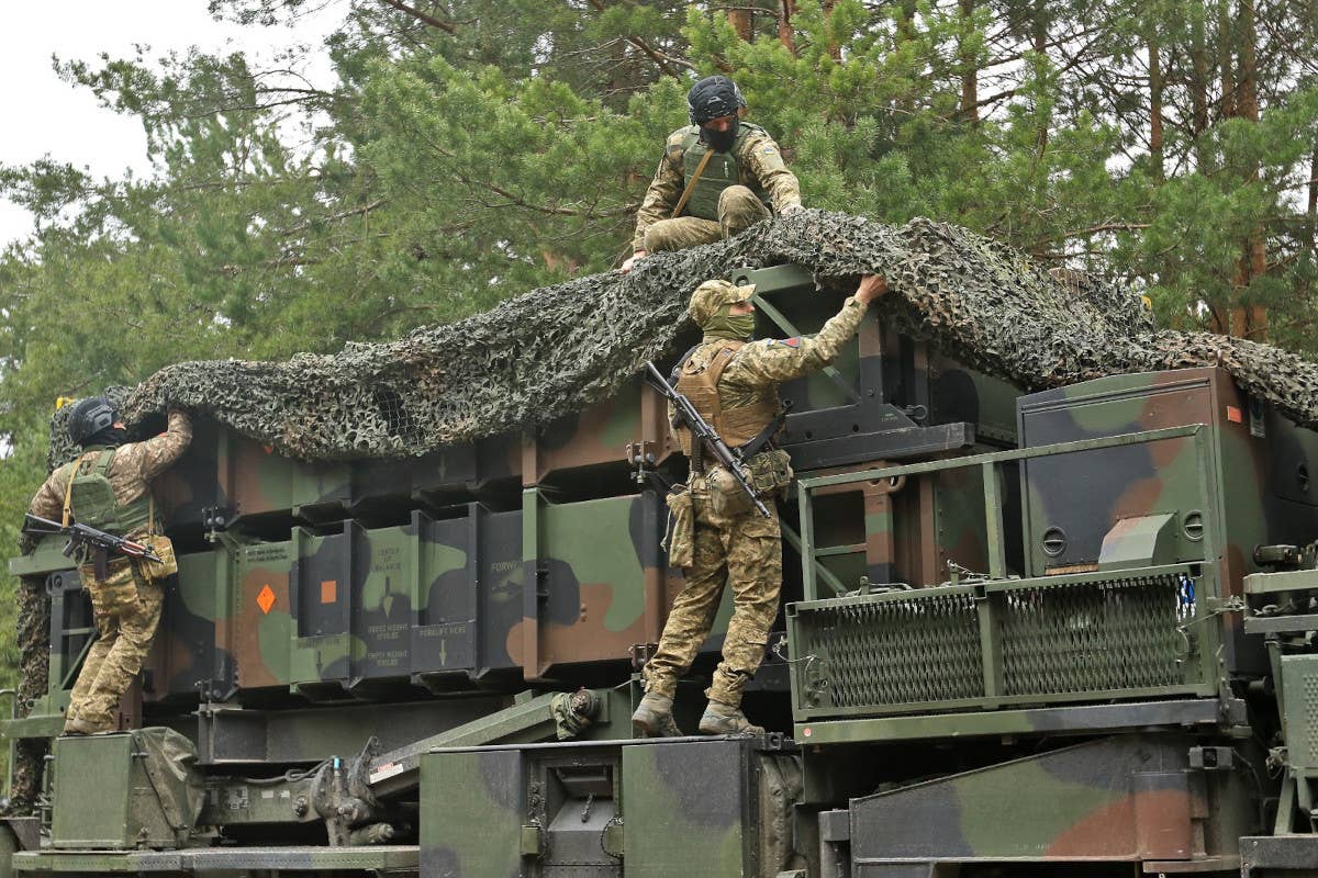 Ukrainian personnel remove camouflage netting from a Patriot launcher, which is loaded with missile canisters associated with older interceptors like the PAC-2-series. <em>Ukrainian Air Force</em>