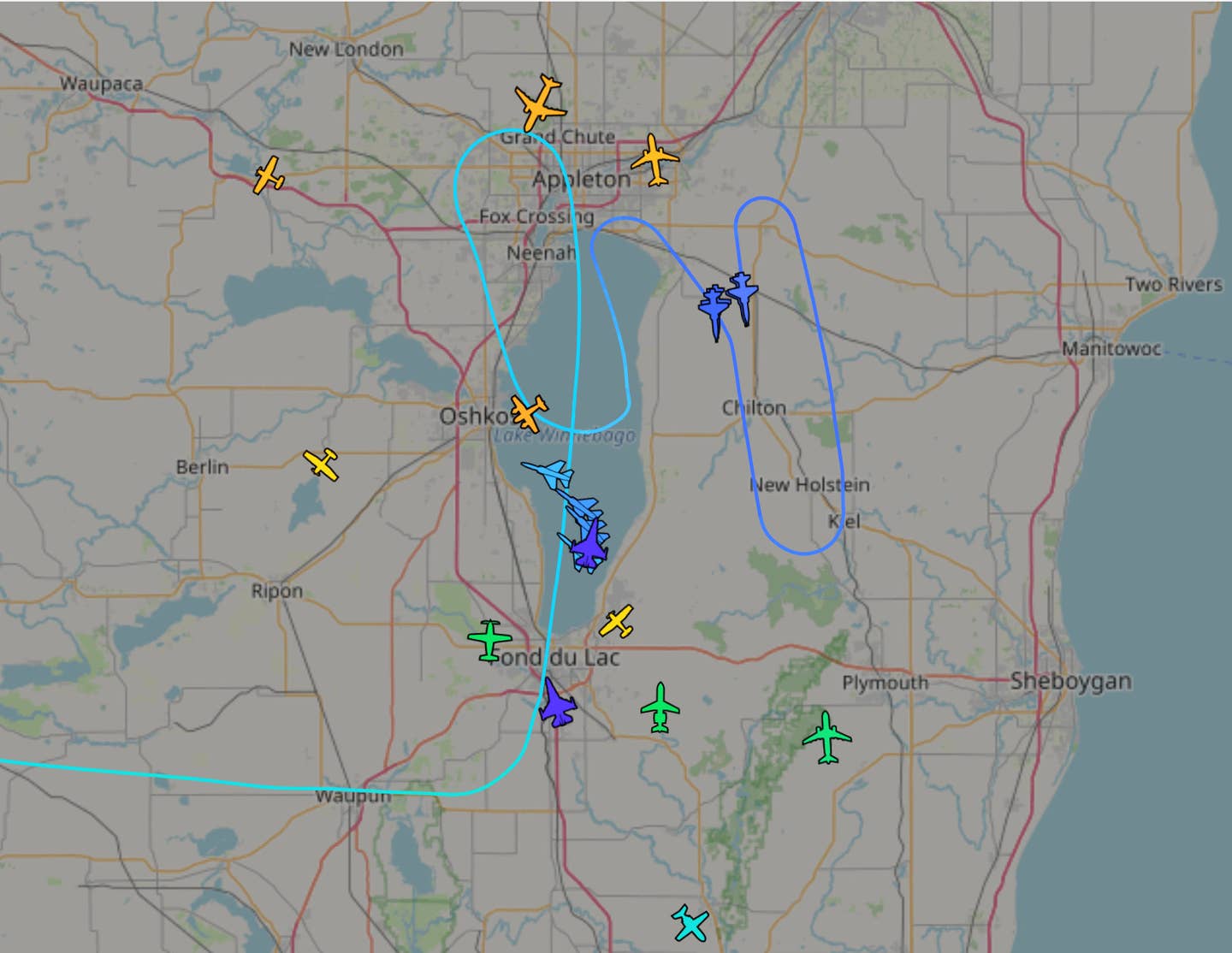 A screen capture showing aircraft being tracked in the vicinity of Volk Field on August 11. Private contractor jets participating in Northern Lightning 2023 are seen here in blue and purple. The relatively limited airspace available and the density of aircraft involved is clearly visible. <em>ADS-B Exchange</em>