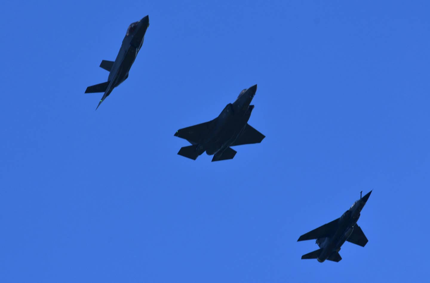 A pair of F-35s, at left, and a Mirage F1 from private red air firm ATAC, at right, fly together during Northern Lightning 2023. <em>Andy Laurent</em>