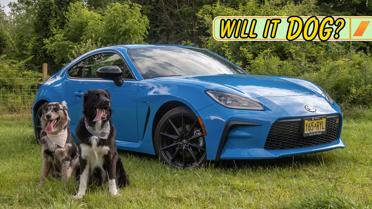 This small sports car is shown in contrast to two dogs, which look fairly large next to it.