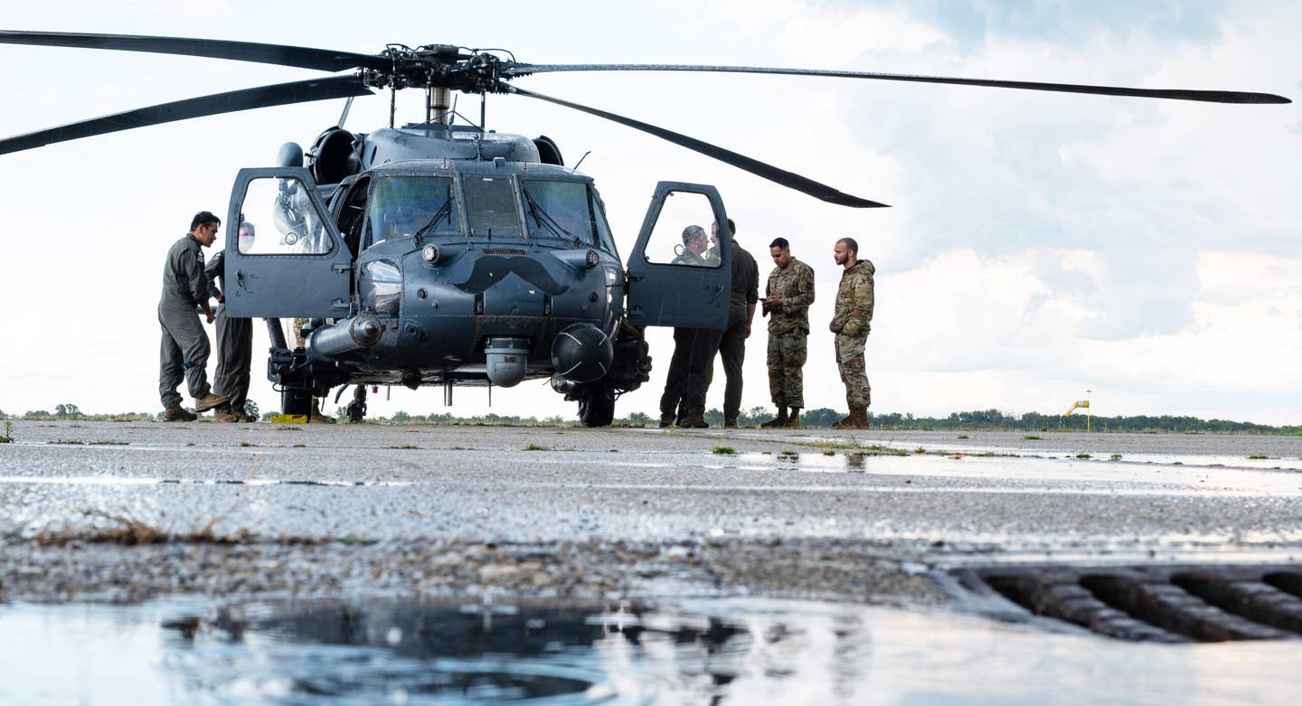 U.S. Air Force airmen assigned to the 435th Contingency Response Support Squadron and 56th Rescue Squadron discuss the agenda for a rotary-wing operation, at Batajnica Air Base, Serbia Aug. 7, 2023. <em>U.S. Air Force photo by Airman 1st Class Edgar Grimaldo</em>