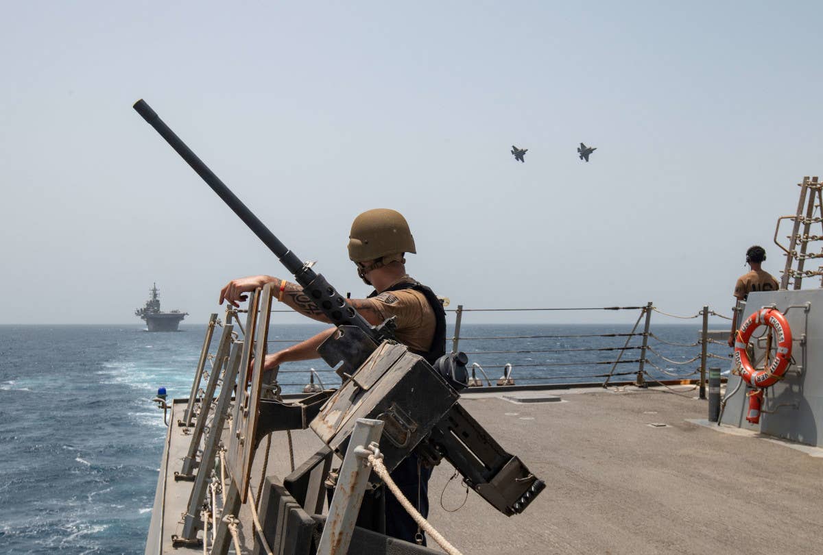 Sailors onboard the USS Thomas Hudner watch a pair of US Air Force F-35A Joint Strike Fighters fly overhead in the Gul of Oman on August 17, 2023. The USS <em>Bataan</em> is seen to the left. USN