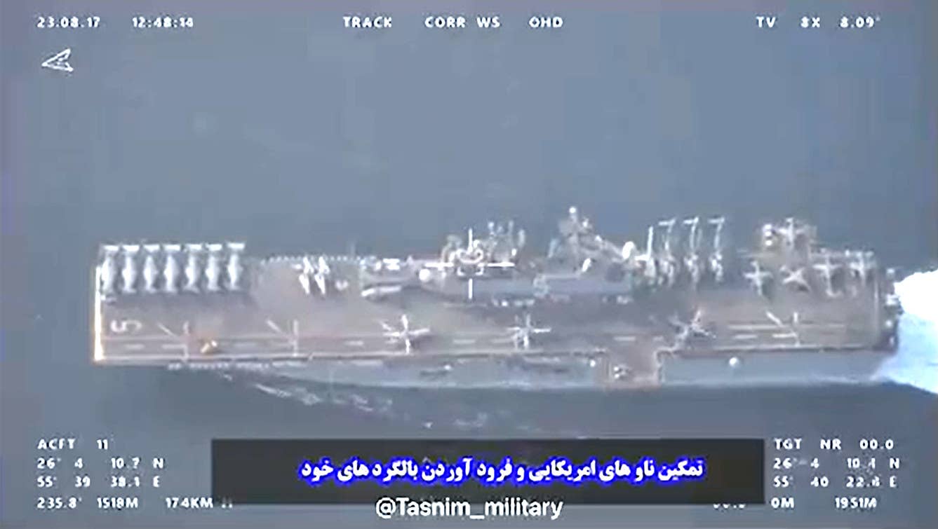 A view of the USS Bataan in the Strait of Hormuz on August 17, 2023, which appears to have been shot by an Iranian drone. Clearly visible on its deck are AV-8B Harriers, MV-22 Ospreys, CH-53E Super Stallions. Other clips from the footage the Iranians released show that the three helicopters positioned along the port side of the flight deck are an AH-1Z Viper, a UH-1Y Venom, and an MH-60 Sea Hawk. Toward the bow on the port side there is what may be a Light Marine Air Defense Integrated System (LMADIS) country-drone system.<em> IRGC capture via Tasnim News Agency</em>