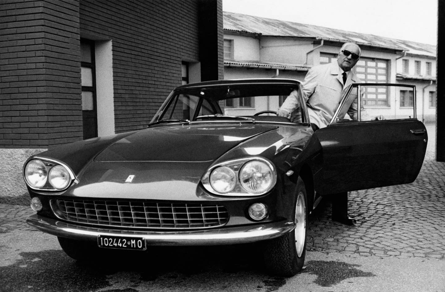 Enzo Ferrari getting out of one of his cars in 1966