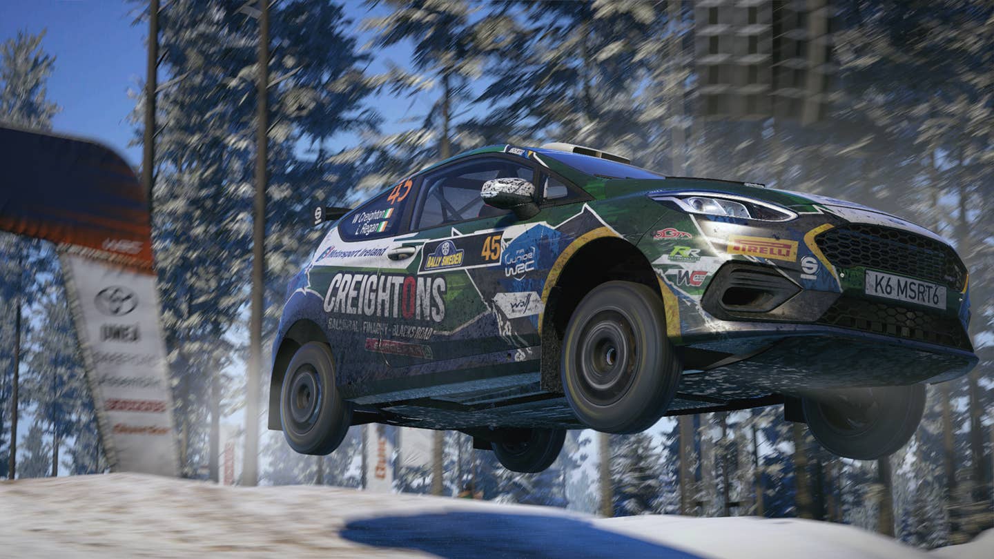 Image from EA Sports WRC of a Ford Fiesta going off a jump on a rally stage.