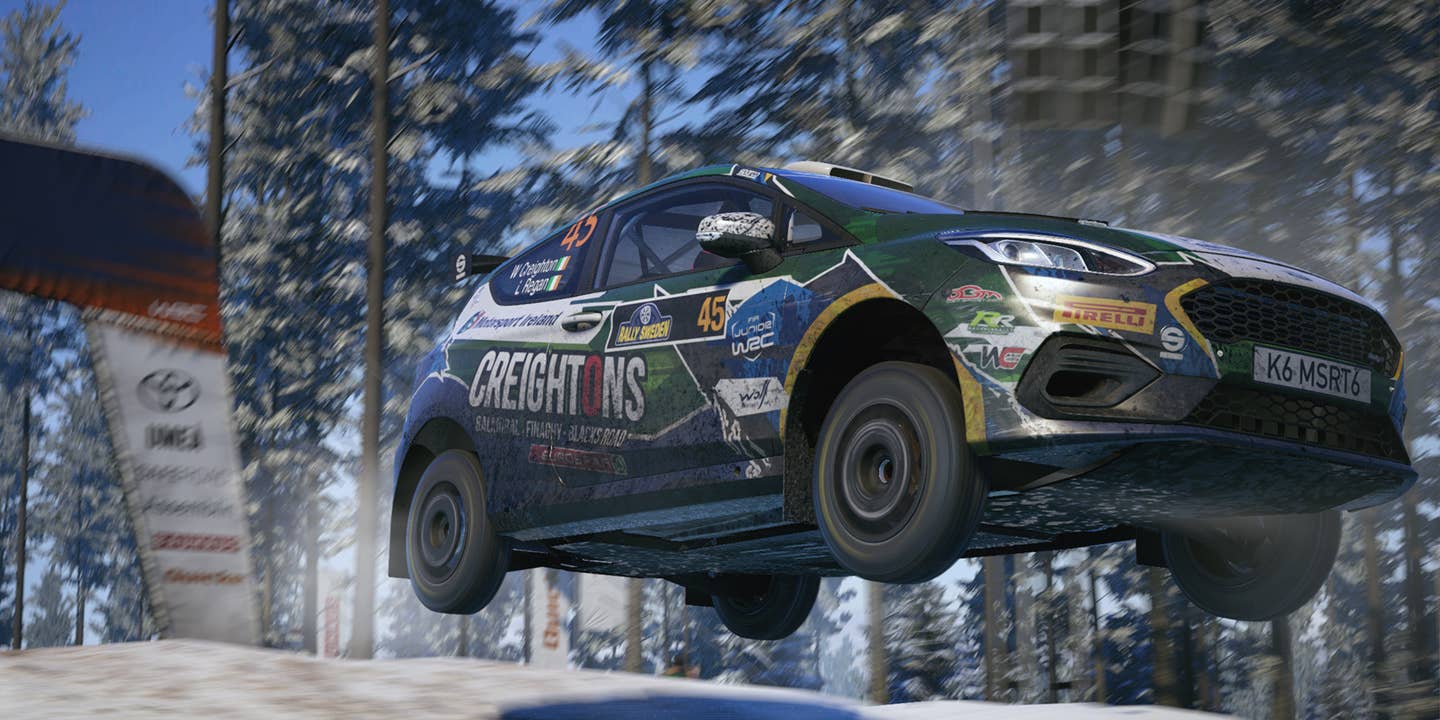 Image from EA Sports WRC of a Ford Fiesta going off a jump on a rally stage.