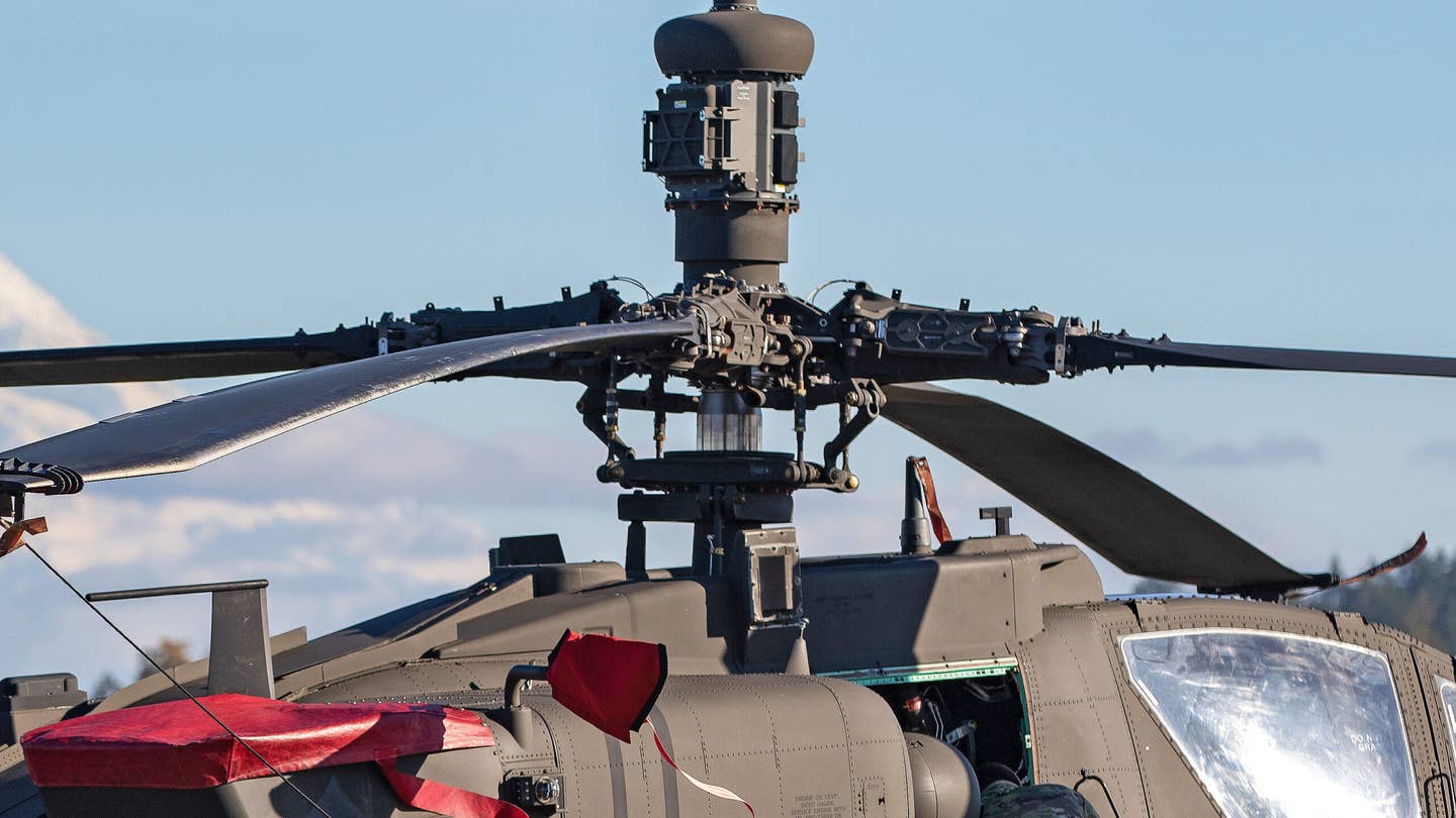 An AH-64E Apache attack helicopter sits at Joint Base Lewis-McChord with a MUMT-X mast attached. (U.S. Army photo by Capt. Kyle Abraham, 16th Combat Aviation Brigade)