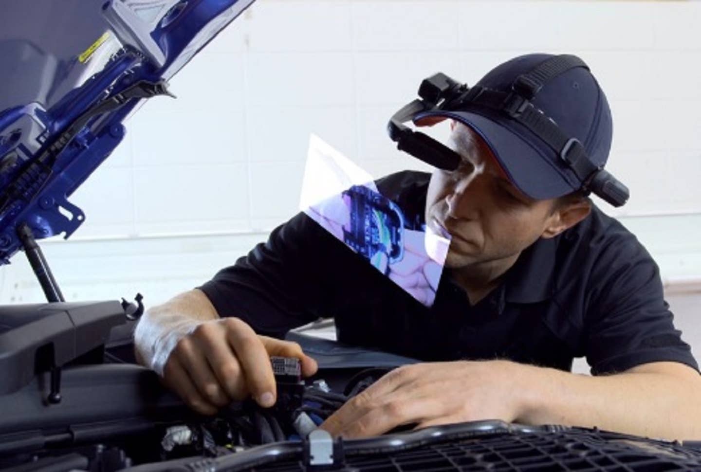 A BMW mechanic uses smart glasses during a repair.