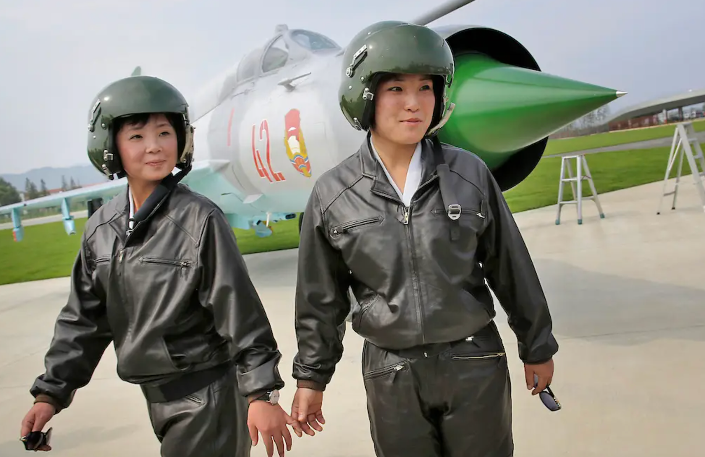 Two female pilots make an appearance in front of a MiG-21 fighter during North Korea’s first airshow in 2016.&nbsp;<em>AP</em>