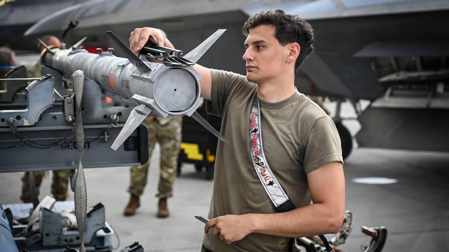 A maintainer prepares an AIM-9X for loading onto an F-22 Raptor. <em>USAF</em>