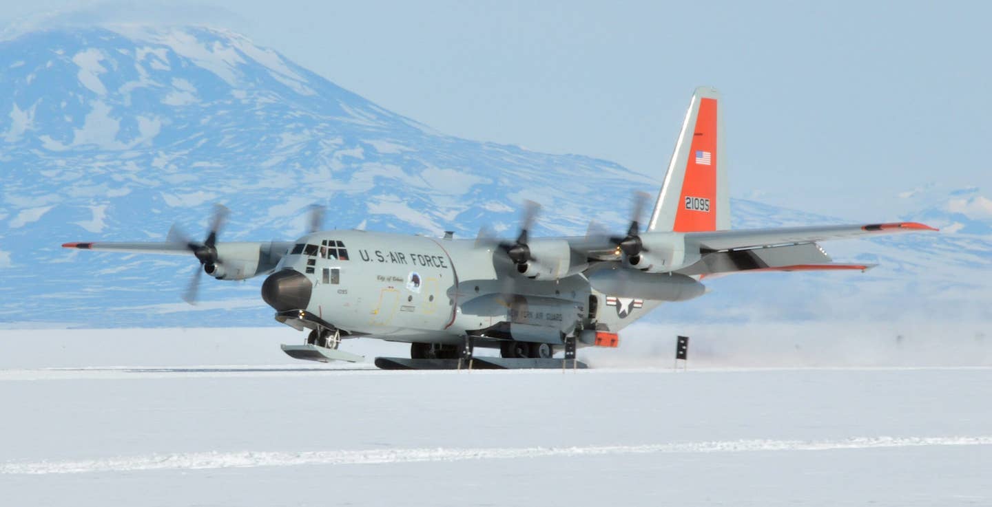 A New York Air National Guard LC-130H lands at McMurdo Station, Antarctica in 2017. An IcePod radar pod is seen loaded onto a sponson fitted to a modified rear paratrooper door on the left side of the aircraft.<em> Air National Guard</em>