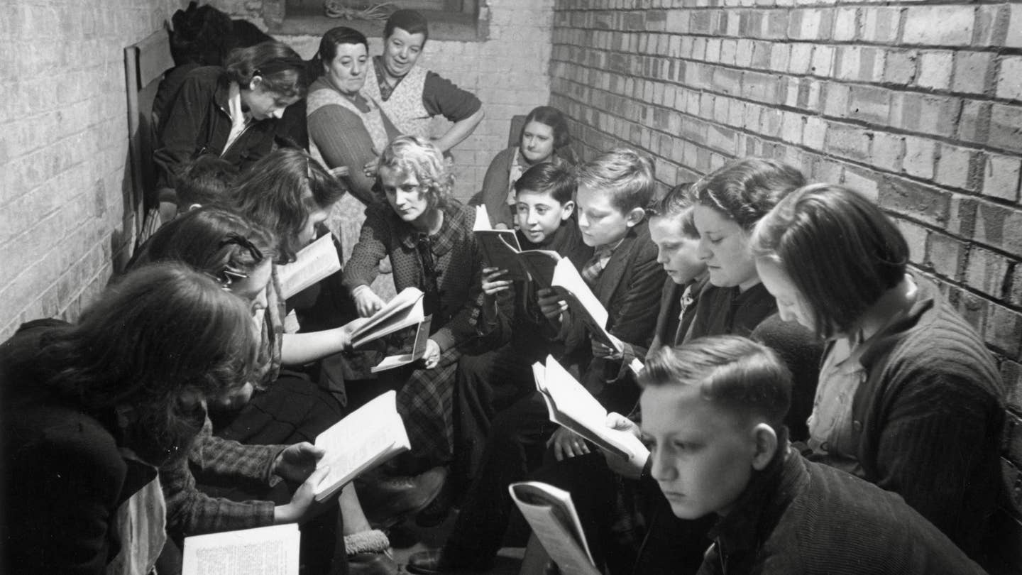 A reading and discussion session in an air raid shelter in Bermondsey, south London, during the Blitz, March 1941. Original Publication: Picture Post - 655 - Down In The Shelter There Is Life - pub. 29th March 1941 (Photo by Bert Hardy/Picture Post/Hulton Archive/Getty Images)