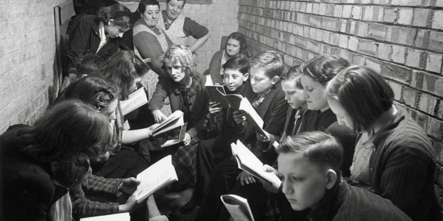 A reading and discussion session in an air raid shelter in Bermondsey, south London, during the Blitz, March 1941. Original Publication: Picture Post - 655 - Down In The Shelter There Is Life - pub. 29th March 1941 (Photo by Bert Hardy/Picture Post/Hulton Archive/Getty Images)